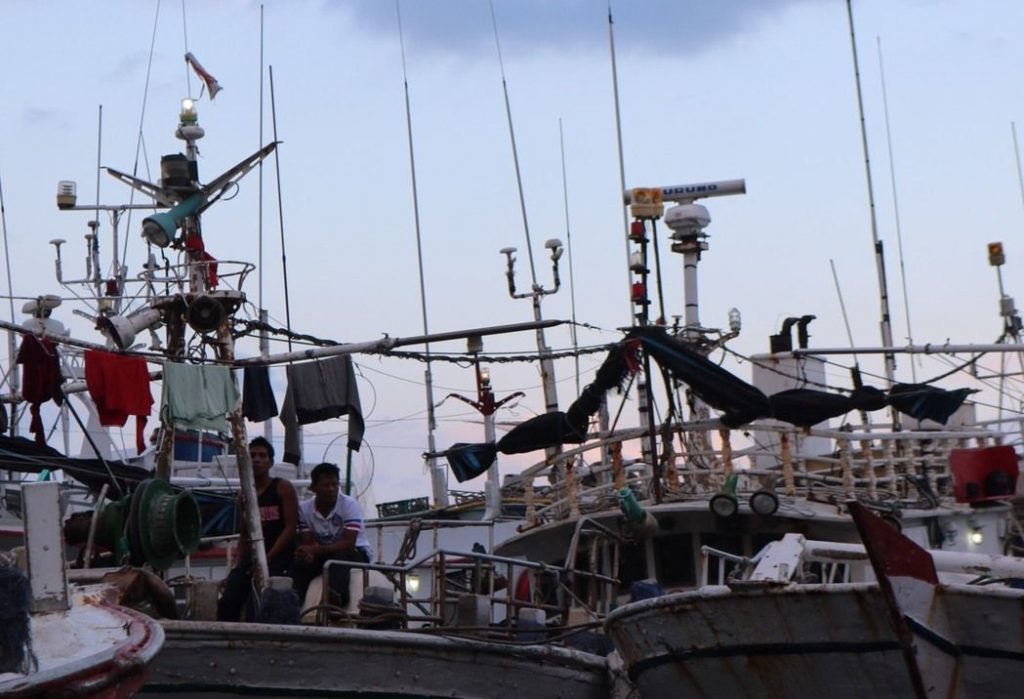 南方澳的外籍漁工趁著出海空檔坐在船頭休息。許多移工帶有發財夢來到台灣，卻感到失望，然而他們也沒有退路。記者陳熙文／攝影